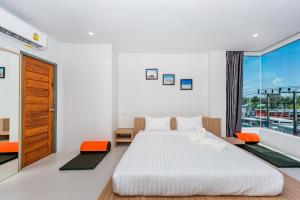 a bedroom with two beds and a large window at Phuket Marine Poshtel - SHA Plus in Chalong 