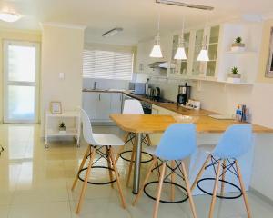 a kitchen with a wooden table and four chairs at Bismarck 2 in Swakopmund