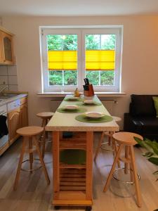 ヴィンターベルクにあるFerienhaus Bergblickのキッチン(テーブル、スツール2脚、窓2つ付)