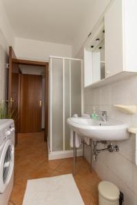 a bathroom with a sink and a washing machine at La Rosa in Ferrara