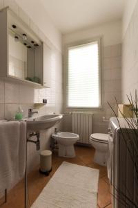 bagno con lavandino, servizi igienici e finestra di La Rosa a Ferrara
