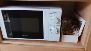 a microwave oven sitting on top of a shelf at Нощувки Ботеви in Shumen