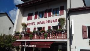 um edifício de hotel com uma varanda com plantas em Hotel Le Beauregard em Divonne-les-Bains