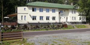 una casa blanca con techo verde al lado de una carretera en Olivin Kytlice en Kytlice