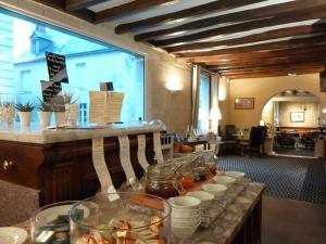 a restaurant with a counter with jars of food at Teritoria Le Grand Monarque in Azay-le-Rideau