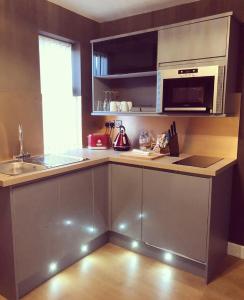 a kitchen with a counter with a sink and a microwave at Bede Apartments in Coventry