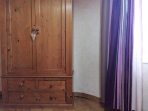 a wooden cabinet sitting next to a curtain at Gite de la Vieille Forge in Beblenheim