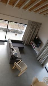 a room with a couch and a chair and a window at Canto do Nemo in Canto da Areia