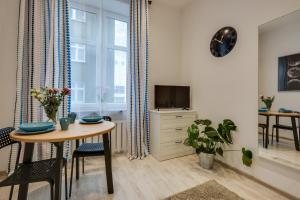 a living room with a table and a tv at KATO Apartamenty Moniuszki in Katowice