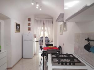ナポリにあるCasa Nel Cuore Di Napoli centro storicoのキッチン(コンロ、テーブル、冷蔵庫付)