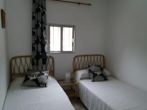 a room with two beds and a window at Casita Canaria in Santa Cruz de Tenerife