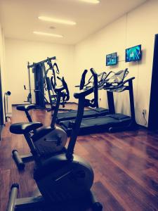 a gym with several tread machines in a room at Nymfes Hotel in Kato Loutraki