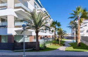 een gebouw met palmbomen ervoor bij El Mirador De Villamartin - La Zenia & Golf in Playas de Orihuela