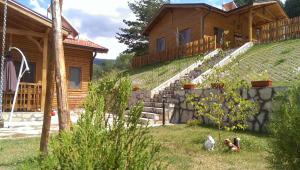 a wooden house with a staircase in front of it at Mini Complex Rilski Terasi in Sapareva Banya