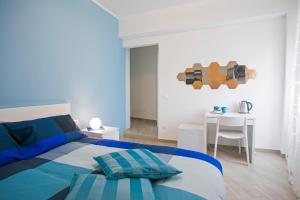 una camera da letto blu e bianca con un letto e un tavolo di B&B Sapore di Mare al Corso a Gaeta