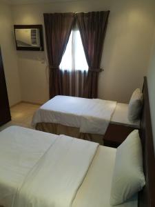 a hotel room with two beds and a window at لين للشقق المخدومة in Jeddah +7 photos