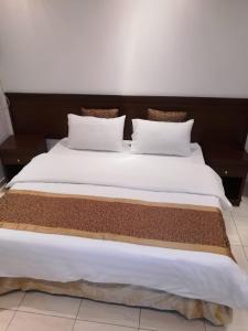 a large bed with white sheets and pillows at لين للشقق المخدومة in Jeddah