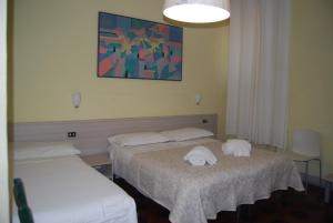 two beds in a room with towels on them at Soggiorno Santa Reparata in Florence
