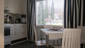 een keuken met een tafel en stoelen en een raam bij M Apartments Tuularinkatu in Tampere