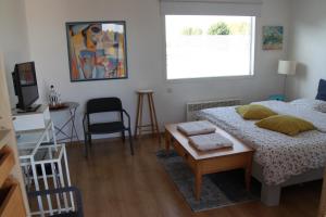 1 dormitorio con cama, mesa y ventana en Studio Art-hill, en Jabbeke