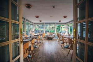 a dining room with tables and chairs and windows at Tynycornel Hotel in Tal-y-llyn
