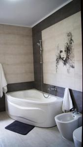 a bathroom with a white tub and a sink at Anemona's House In The Center Of Sibiu in Sibiu