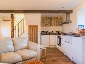 a living room with a couch and a kitchen at The End Place in Pateley Bridge