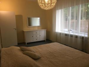 1 dormitorio con cama, espejo y lámpara de araña en Liivalaia Apartment, en Tallin