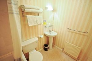 a small bathroom with a toilet and a sink at Denewood Hotel in Bournemouth