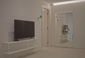 a living room with a flat screen tv on a white wall at Casa Bacca apartments in Trento