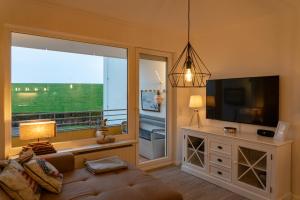 Una sala de estar con una gran ventana y un televisor. en Seedeich, en Cuxhaven