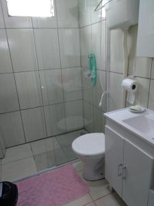 y baño con ducha, aseo y lavamanos. en Casa de aluguel Gregório, en Imbituba