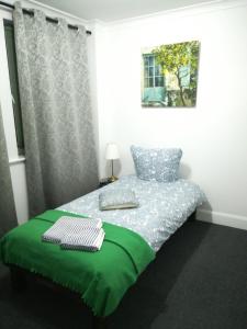 a bedroom with a bed with a green blanket at Royal Guest House II in Viersen