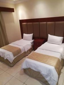 two beds sitting next to each other in a room at Leen Serviced Apartments in Jeddah