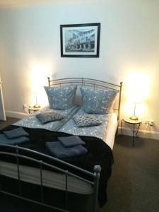 a bedroom with a bed with blue pillows and two lamps at Royal Guest House II in Viersen