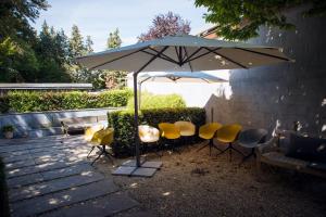 una mesa y sillas bajo una sombrilla en un patio en Hotel Carpinus, en Lovaina