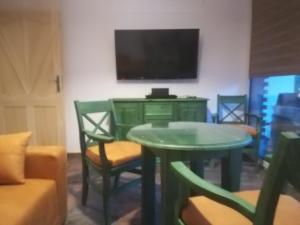 シュチルクにあるApartament Zielonyのリビングルーム(テーブル、椅子、テレビ付)