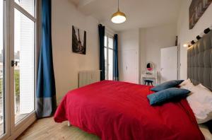 トロワにあるAu Coeur de Villeのベッドルーム1室(赤いベッド1台、大きな窓付)