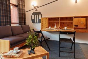 BASE CAMP alpine apartments في بيريول تشيرفينيا: غرفة معيشة مع أريكة وطاولة