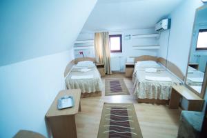 Habitación hospitalaria con 2 camas y espejo en Pensiunea Melisa, en Tulcea