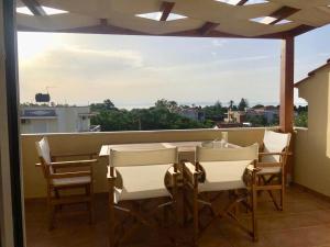 d'une table et de chaises sur un balcon avec vue. dans l'établissement The Loft, à Chios