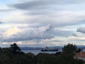 a large boat on the water under a cloudy sky at The Loft in Chios