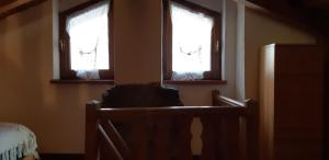 due finestre in una stanza con una sedia davanti di Casetta di montagna Viuex a La Magdeleine