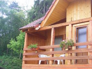 a wooden house with two chairs and flowers on it at Complex Turistic Ocna Sibiului in Ocna Sibiului