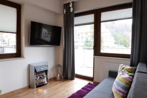 Televízia a/alebo spoločenská miestnosť v ubytovaní Apartamenty Kora