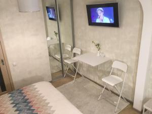 a room with a table and chairs and a tv at Дворик на Жуковского in Odesa