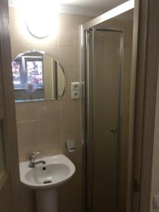 a bathroom with a sink and a shower with a mirror at Дворик на Жуковского in Odesa
