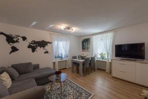 a living room with a couch and a world map on the wall at Muhusin Apartments in Aarau