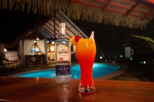 eine Flasche Alkohol und ein Getränk auf dem Tisch in der Unterkunft Namuwoki Lodge in Puerto Viejo