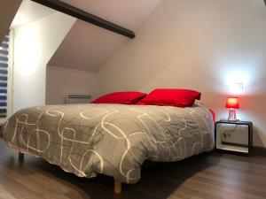 a bedroom with a large bed with red pillows at Villa Napoléon in Pierrefonds